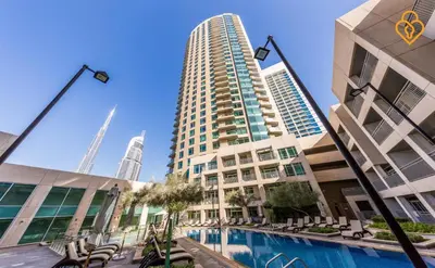 a building with a swimming pool in front of a tall building at Keysplease Upgraded 1 BR Apt near Dubai Mall, Burj Views in Dubai