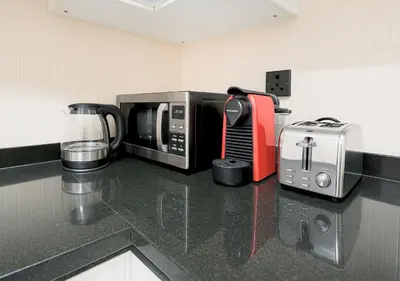 a kitchen counter with a microwave and a toaster at DreamShoma- Super Spacious 1BR Lake View in Dubai