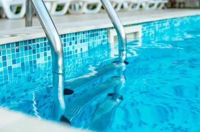 a swimming pool with blue tiles on the water at Diamond Marina Inn, Heart of Marina in Dubai