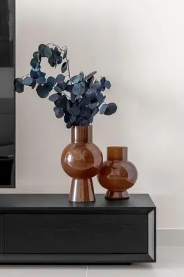 two vases with flowers in them on a table at Palm-View 2BR Elie Saab Luxury in Dubai