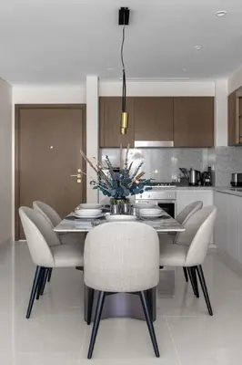a kitchen with a dining room table and chairs at Palm-View 2BR Elie Saab Luxury in Dubai