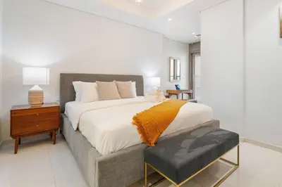 a bedroom with a large bed with a nightstand and a bed sidx sidx sidx at Sky-High Infinity Pool with Burj Khalifa Views in Dubai