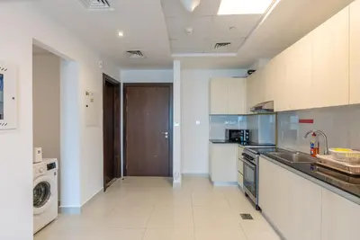 a kitchen with a sink and a dishwasher at 1 Bedroom in JVC in Dubai