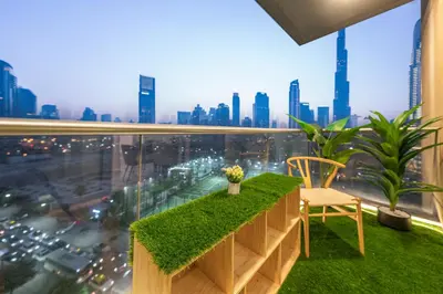 a balcony with green grass and a view of a city at & Burj Luxury Living 2bhk Direct Burj Khalifa View in Dubai