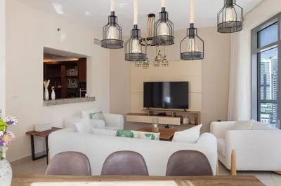 a living room with white furniture and a tv at Beautiful Marina Views 1 Bed in Dubai