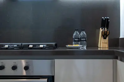 a kitchen with two bottles of water on a counter at TRPS - Peninsula Five, Business Bay - Stylish 1BR - Canal & Burj Khalifa Views in Dubai