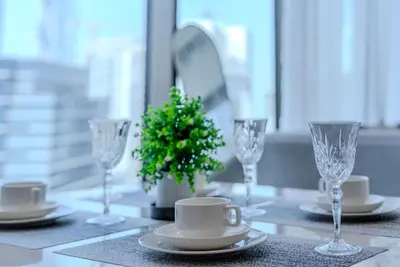 a table with glasses and a christmas tree on it at TRPS - Peninsula Five, Business Bay - Stylish 1BR - Canal & Burj Khalifa Views in Dubai