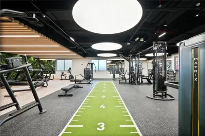 a gym with a green floor in the middle at Spacious 1 BHK with City Views Near Burj Khalifa in Dubai
