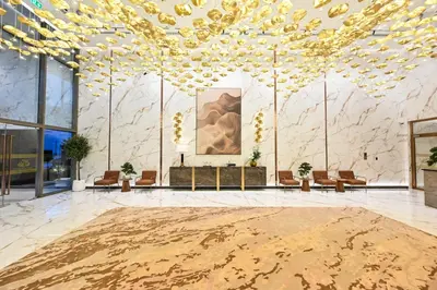 a large lobby with a large ceiling with gold chandeliers at Spacious 1 BHK with City Views Near Burj Khalifa in Dubai