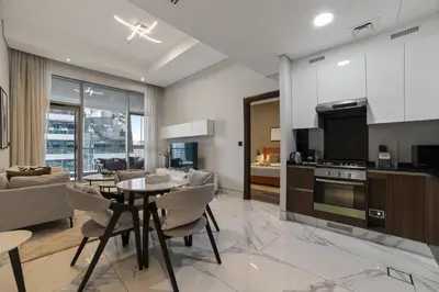 a kitchen and living room with a table and chairs at Modern Apartment with Canal Views, Near Dubai Mall and Burj Khalifa in Dubai