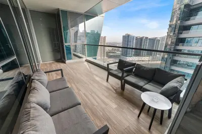 a living room with couches and a view of a city at Modern Apartment with Canal Views, Near Dubai Mall and Burj Khalifa in Dubai