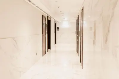 a hallway with white marble floors and doors at Modern Apartment with Canal Views, Near Dubai Mall and Burj Khalifa in Dubai