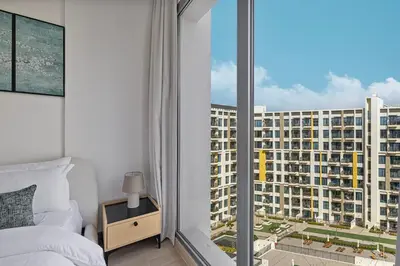 a bedroom with a view of a large building at The Queens Tranquil Oasis 1BDR in Dubai