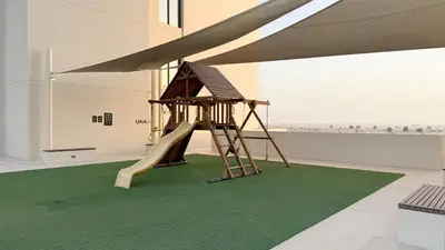 a playground with a slide on a green carpet at The Queens Tranquil Oasis 1BDR in Dubai