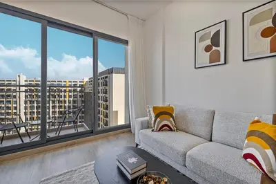 a living room with a couch and a large window at The Queens Tranquil Oasis 1BDR in Dubai