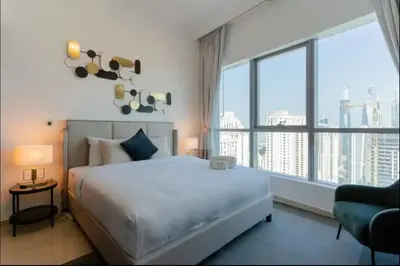 a bedroom with a large bed and a large window at AWS Holiday Homes - Comfort and Marina Views in Dubai