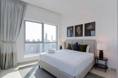 a white bedroom with a large bed and a large window at AWS Holiday Homes - Comfort and Marina Views in Dubai