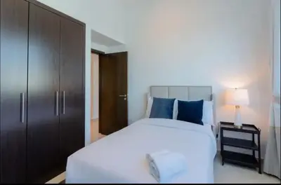 a bedroom with a large white bed with blue pillows at AWS Holiday Homes - Comfort and Marina Views in Dubai