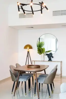 a dining room with a table and chairs and a mirror at AWS Holiday Homes - Comfort and Marina Views in Dubai
