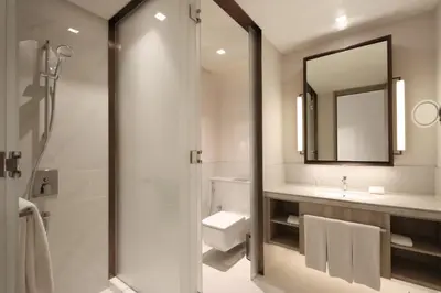 a bathroom with a shower and a sink and a mirror at Livbnb - Premium 3BR with Burj Skyline View in Dubai