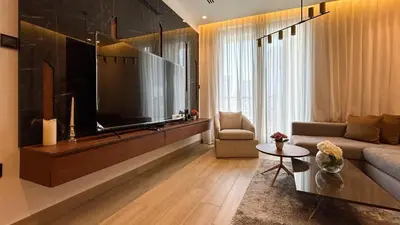 a living room with a large flat screen tv at Bespoke Holiday Homes - Cozy 1BR Retreat in Haven Residences JVC in Dubai