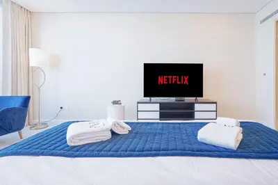 a bedroom with a bed with a tv on it at PVH - Palm Tower - Inviting Studio with Sea View in Dubai