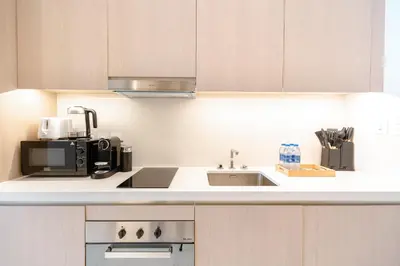 a kitchen with a sink and a microwave at PVH - Palm Tower - Inviting Studio with Sea View in Dubai
