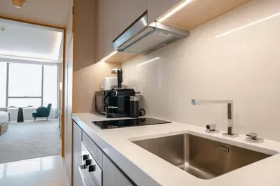 a kitchen with a sink and a coffee maker at PVH - Palm Tower - Inviting Studio with Sea View in Dubai