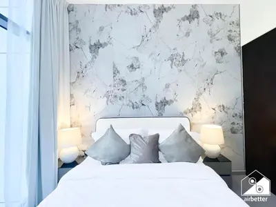 a bedroom with a white bed and a marble wall at Luxury 2B in Business Bay & Stunning Canal Views in Dubai