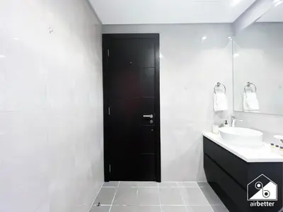 a black door in a white bathroom with a sink at Luxury 2B in Business Bay & Stunning Canal Views in Dubai