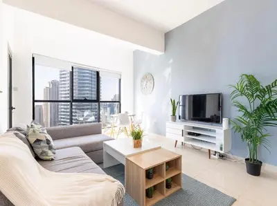 a living room with a couch and a tv at Golden Hour Stay Sea View in Marina Dubai in Dubai