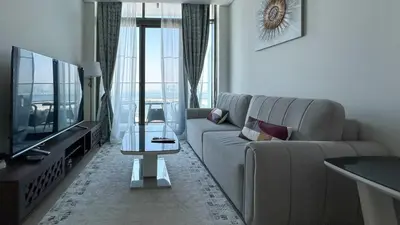 a living room with a couch and a tv at Bespoke Holiday Homes - 1BR Apartment with Creek View in Al Jaddaf in Dubai
