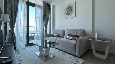 a living room with a couch and a glass table at Bespoke Holiday Homes - 1BR Apartment with Creek View in Al Jaddaf in Dubai