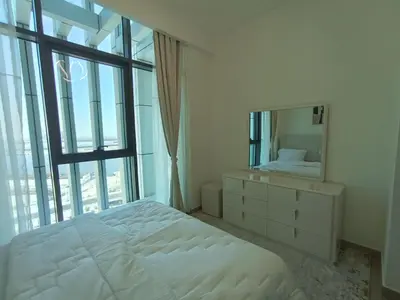 a white bedroom with a bed and a mirror at Bespoke Holiday Homes - 1BR Apartment with Creek View in Al Jaddaf in Dubai