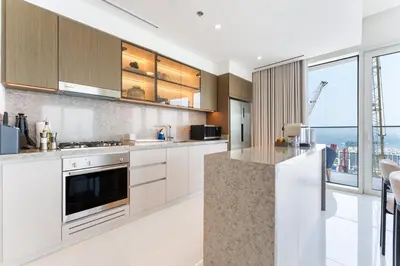 a kitchen with white cabinets and a large window at Upscale 2-BR with Sea View - Grand Bleu by Elie Saab in Dubai