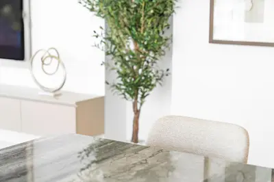 a table with a chair and a tree in a room at Upscale 2-BR with Sea View - Grand Bleu by Elie Saab in Dubai