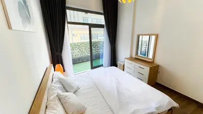 a bedroom with a bed and a large window at Joya Verde Residence - 1BHK Huge Apartment in Dubai