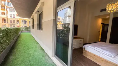 a room with a balcony with green grass at Joya Verde Residence - 1BHK Huge Apartment in Dubai
