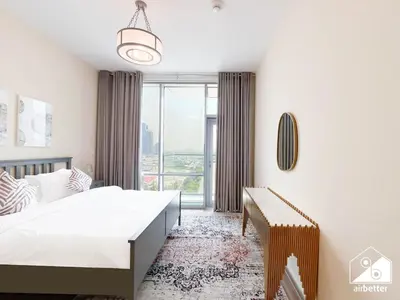 a bedroom with a bed and a large window at Stunning 2-Bedroom Apartment with Canal Views in Dubai