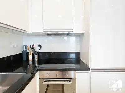 a kitchen with white cabinets and a stove top oven at Wonderful 2B with Canal Views at Amna Tower in Dubai