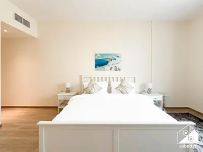 a white bedroom with a large white bed in it at Wonderful 2B with Canal Views at Amna Tower in Dubai
