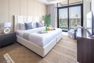 a bedroom with a large white bed and a desk at Frank Porter - Nobles Tower in Dubai
