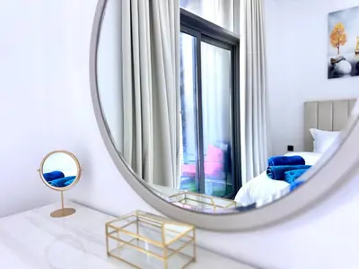 a mirror in a room with a bed and a chair at 5 Star Apartment Dubai Burj KhalifaView in Dubai