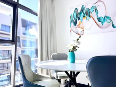 a table with chairs and a vase of flowers on it at 5 Star Apartment Dubai Burj KhalifaView in Dubai