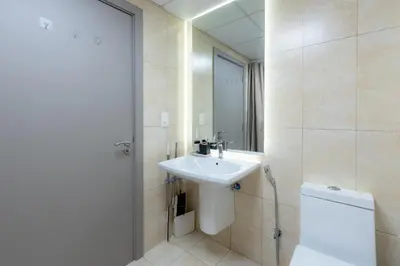 a bathroom with a sink and a toilet and a mirror at Serene studio apartment with Burj Khalifa view in Jumairah Village Circle JVC in Dubai