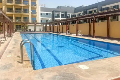a large swimming pool on top of a building at Serene studio apartment with Burj Khalifa view in Jumairah Village Circle JVC in Dubai