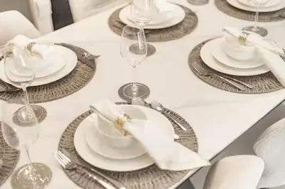 a table with plates and wine glasses on it at 2BR Next to Burj Khalifa& Dubai Mall in Grande Residence in Dubai