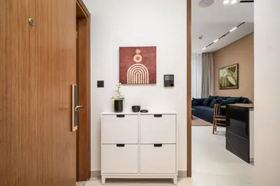 a hallway with a white cabinet and a living room at Trillionaire Bayhouse - Chic 1BR with Views, Pool and Gym in Dubai