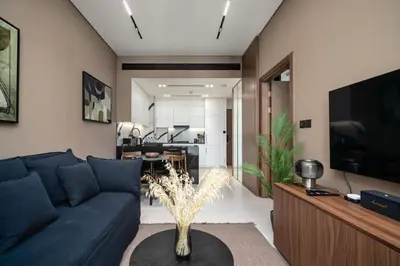 a living room with a blue couch and a tv at Trillionaire Bayhouse - Chic 1BR with Views, Pool and Gym in Dubai