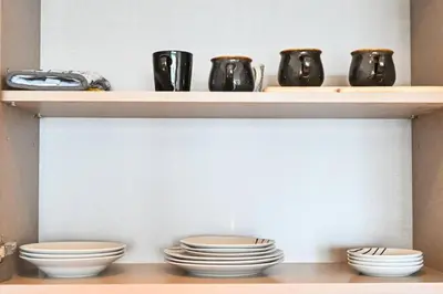 a shelf with plates and cups on it at Comfy 2BR Act 1 Near Dubai Mall in Dubai